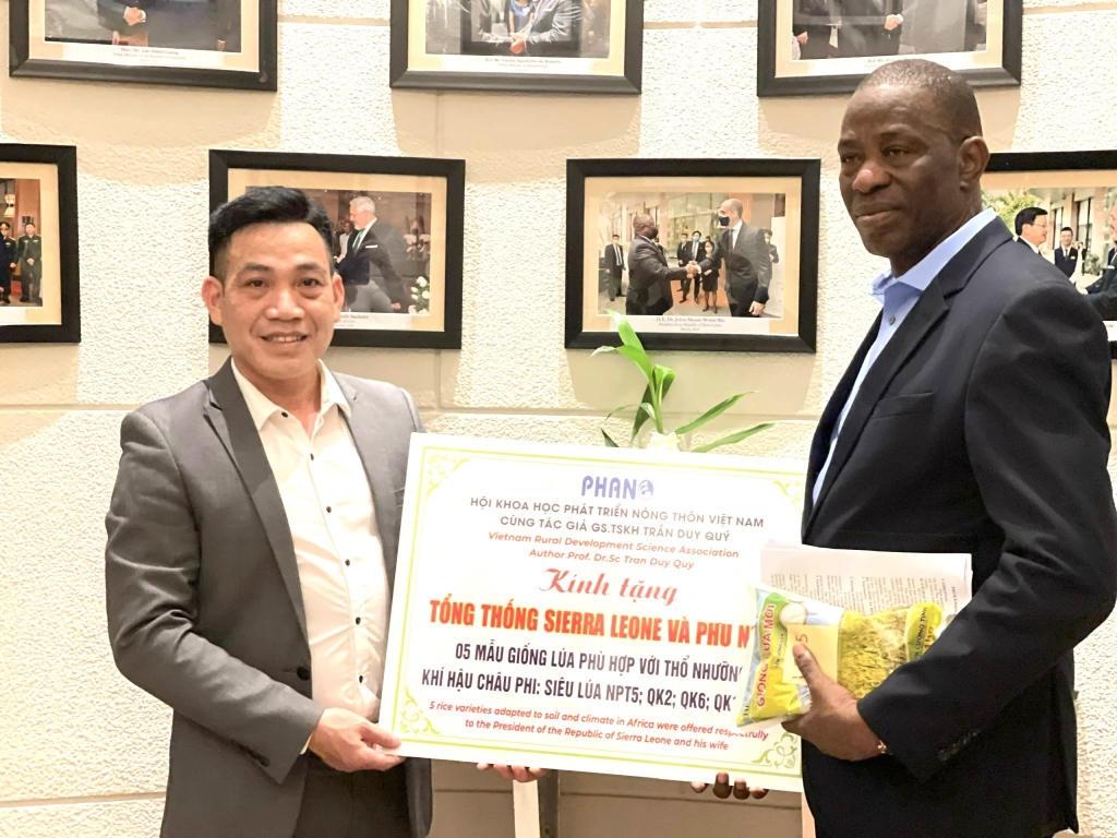 Nhà báo Vương Xuân Nguyên trong vai trò Phó Chánh Văn phòng Hội Khoa học PHANO trao biểu trưng hỗ trợ Sierra Leone một số tiêu bản giống nông nghiệp