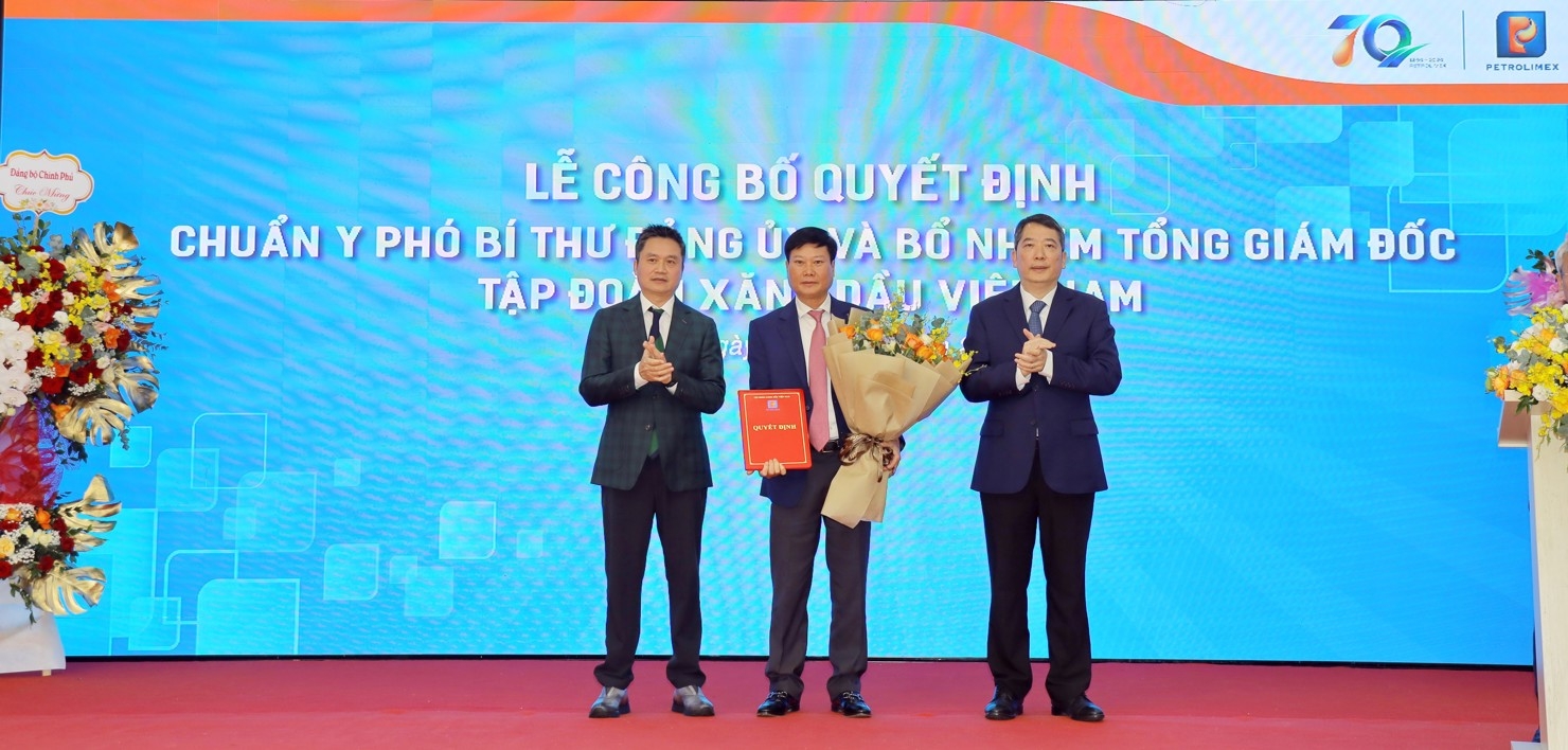 Thứ trưởng Bộ Tài Chính Cao Anh Tuấn  (phải) và ông Phạm Văn Thanh (trái) trao Quyết định bổ nhiệm và tặng hoa chúc mừng tân Tổng Giám đốc Petrolimex Lưu Văn Tuyển.